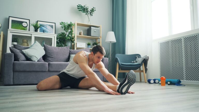 Persona estirándose en casa después de entrenar